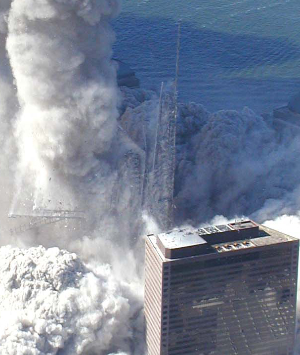 Figure 7. (9/11/2001) WTC1 steel core columns remaining upright after surrounding building aerosolization, showing the spire steel beams disintegrating into dust.
<br>
- Photo by Det Greg Semendinger, NYC Police Aviation Unit
