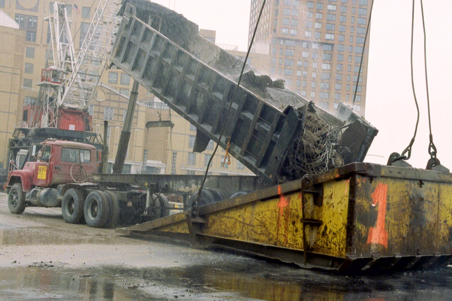 Debris truck with water sprayed onto it showing no steam production, confirming temperature below 100 degrees Celsius, while athermal aerosol emission continues
