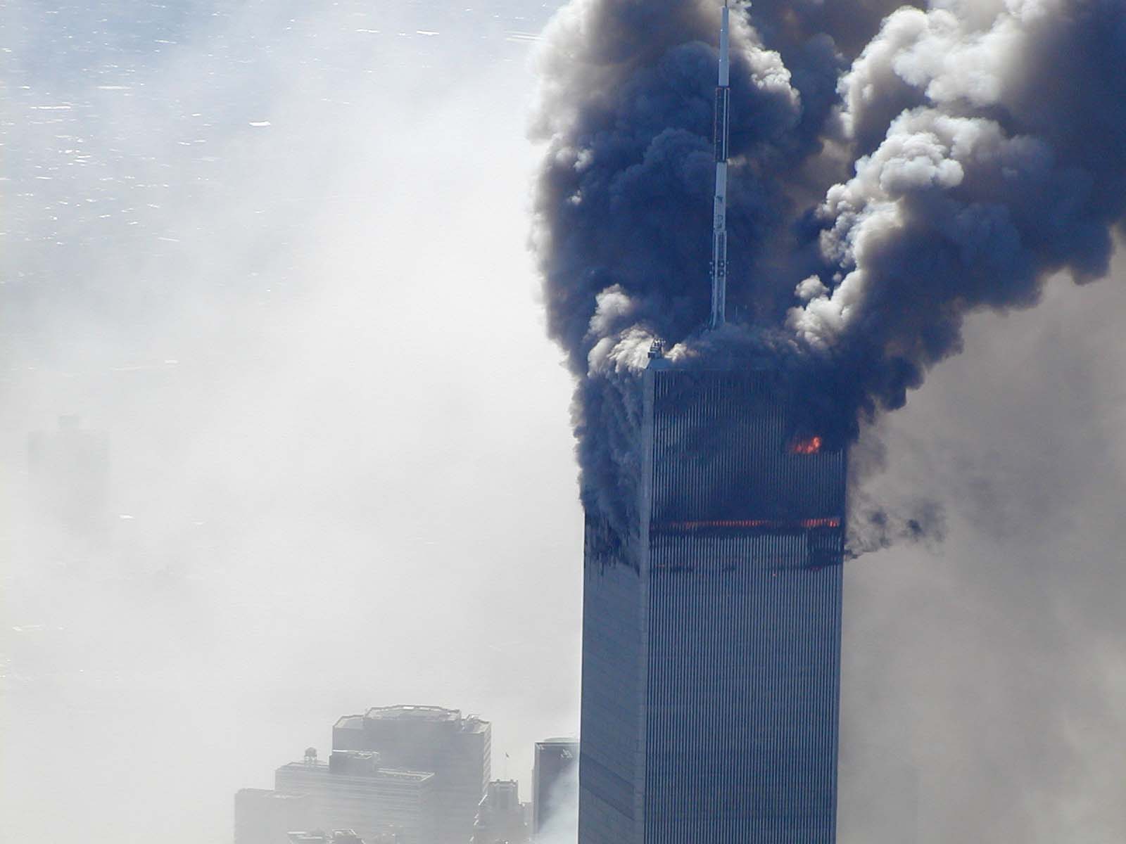 Figure 16. (9/11/2001) WTC1 emitting distinct toroidal vortex structures from north face, with a localized glow without obvious external flame tongues
<br>
- Photo by Det Greg Semendinger, NYC Police Aviation Unit