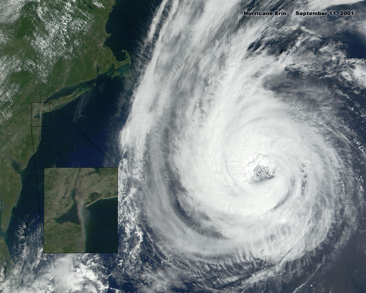 Figure 128. (9/11/01) Satellite view of Hurricane Erin showing Category 3 structure during anomalous near-stall period on September 11, 2001. Inset showing rising fumes from WTC site demonstrating atmospheric ionization and dielectric saturation effects. The dark fumes are moving west and dissipating, but the lighter fumes are heading due south.<br>- Image by NASA