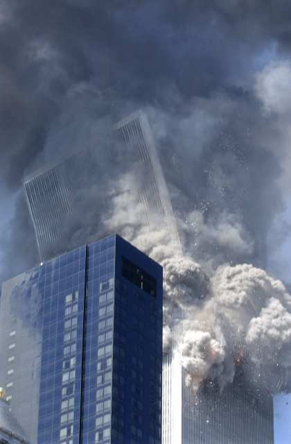 Figure 21. (9/11/2001) WTC2 top block tilting eastward, showing initial angular momentum vector before dissociation.
  <br>
  - Photo by Amy Sancetta/AP
