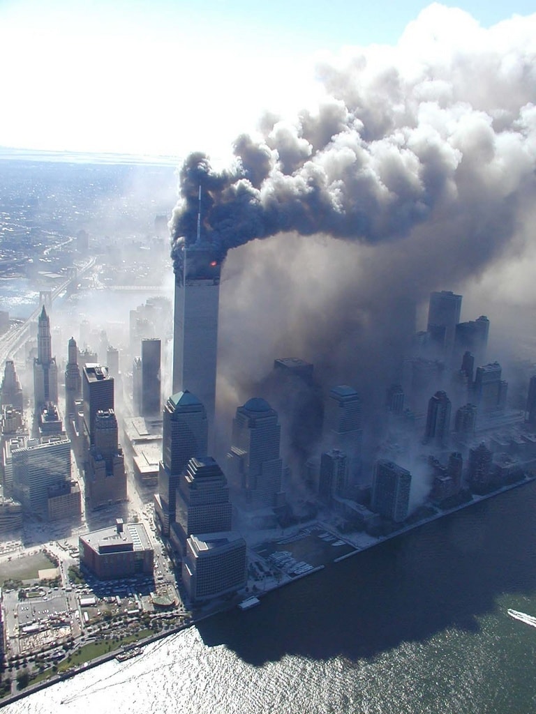 Figure 93. (9/11/01)  Aerial view showing distinct coloration in clouds with dense dark fumes from WTC1 and lighter white dust from WTC2, demonstrating heterogeneous aerosol separation\<br>- Photo by Det Greg Semendinger, NYC Police Aviation Unit