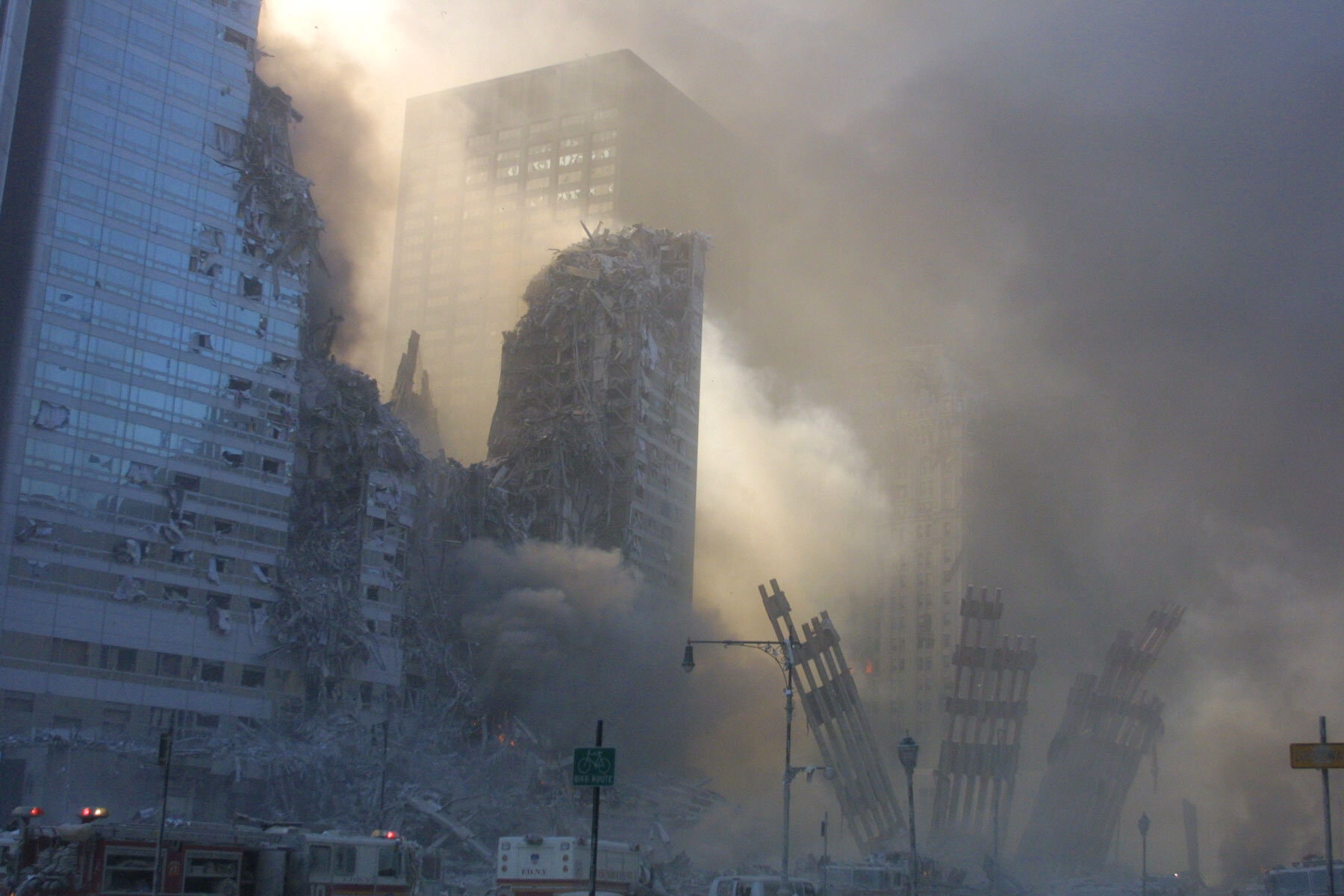 Figure 24. (9/11/01) WTC3 showing a missing section after the destruction of WTC2 and just before the destruction of WTC1. WTC 3 exhibiting progressive structural subtraction and near-total volumetric disappearance. <br>- Photo Copyright 2001 by Bill Biggart/SIPA Press