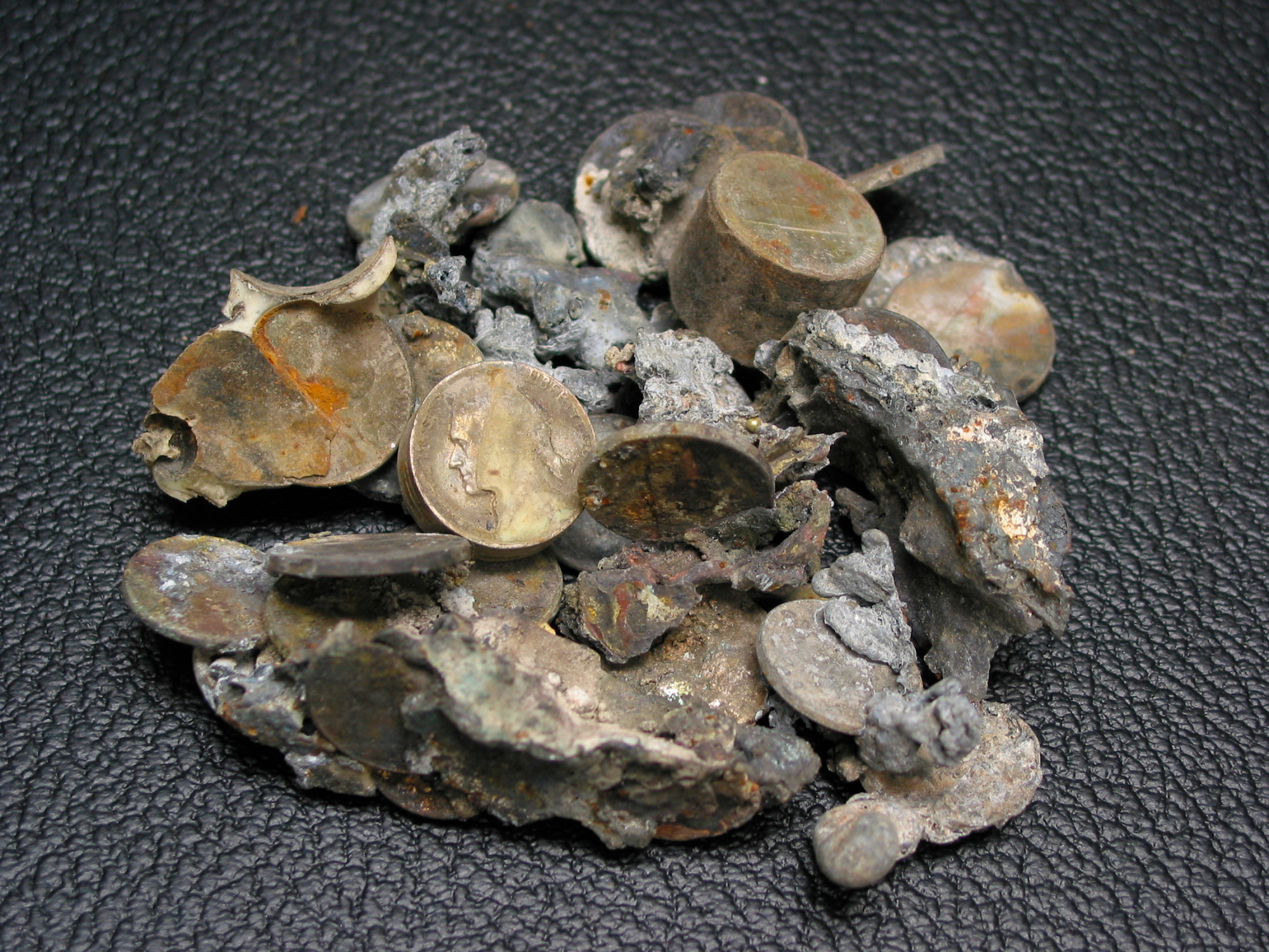 Figure 37. Group of fused coins recovered from the debris of the World Trade Center. Fused cluster of U.S. coinage containing zinc-rich pennies and copper-nickel coins with individual minted relief and geometric integrity preserved